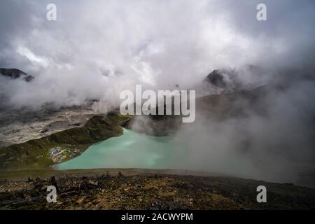 Vue Aérienne Vue panoramique sur Lac Gokyo, Ngozumpa glacier et le village depuis le sommet du Gokyo Ri, nuages de mousson déménagement dans Banque D'Images