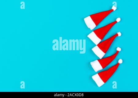 Vue de dessus od rouge élégant Santa hats sur fond coloré. Joyeux Noël concept avec copie espace. Banque D'Images