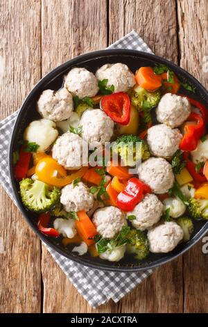 Soupe de poulet sain avec des boulettes de viande et légumes close-up dans une assiette sur la table. Haut Vertical Vue de dessus Banque D'Images