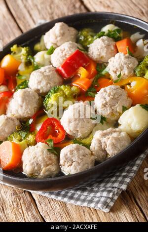 Soupe de légumes avec boulettes de poulet close-up dans une assiette sur la table verticale. Banque D'Images