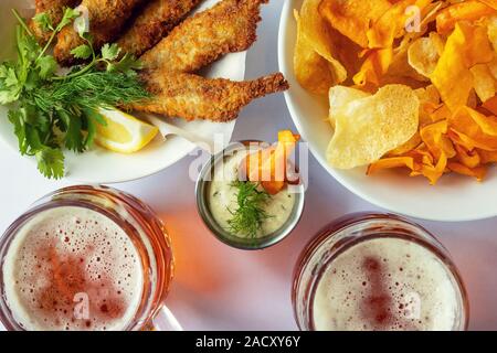 Mug avec la bière et des collations. Le poisson frit avec des frites et de la sauce. Banque D'Images