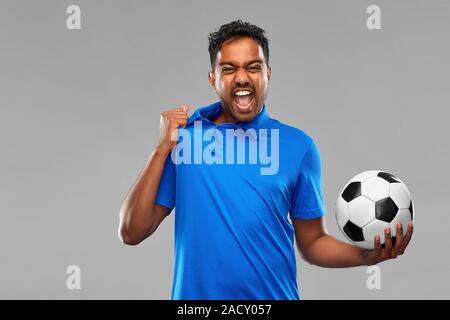 Sport, loisirs et jeux concept succès émotionnel - indien ou fan de football avec ballon de soccer sur fond gris Banque D'Images