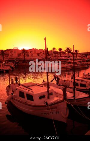 Coucher de soleil sur le bateaux de plaisance dans le port de plaisance de Cala'n Bosch, à l'île de Menorca, Baléares, Espagne Banque D'Images