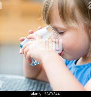 Fille de l'eau potable. Cute little girl drinking water outdoors - très faible profondeur de champ (girl's eye est parfaitement sharp) Banque D'Images