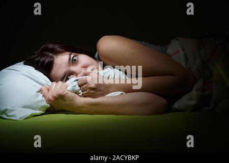 Jeune femme au lit avec les yeux ouverts souffrant d'insomnie. Concept et problèmes de sommeil cauchemar Banque D'Images