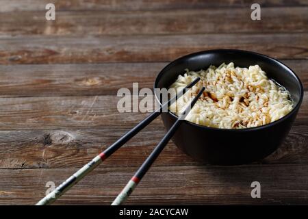 Bol de nouilles avec des légumes sur la table en bois Banque D'Images