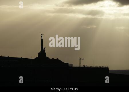 Vue sur le coucher du soleil d'Aberystwyth prise en novembre depuis la promenade montrant les bâtiments en silhouette Banque D'Images