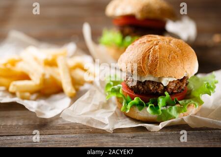 Savoureux faits maison burger et frites sur table en bois Banque D'Images