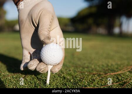 Close up de joueurs de golf ball on tee main mise Banque D'Images