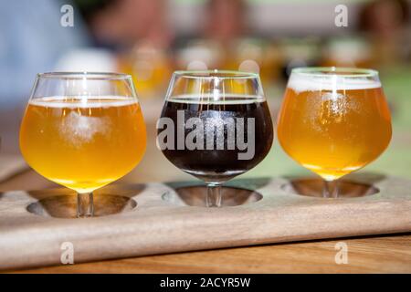 Verres de différentes sortes de Dark and Light bière sur table en bois en ligne. De délicieuses boissons froides sont prêts pour une grande partie de l'ami(e). Concept de dri Banque D'Images