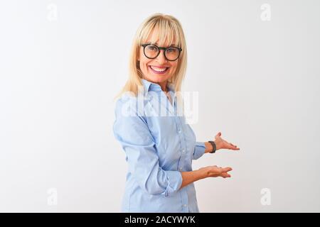 L'âge moyen man shirt et lunettes sur fond blanc isolé invitant à entrer smiling natural avec main ouverte Banque D'Images