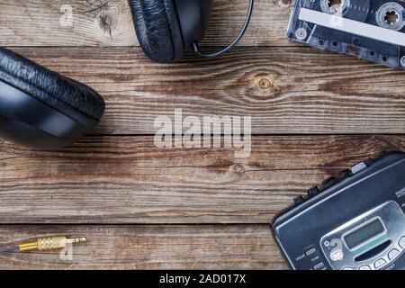 K7, lecteur de cassettes et d'écouteurs sur la table en bois. vue d'en haut. Banque D'Images