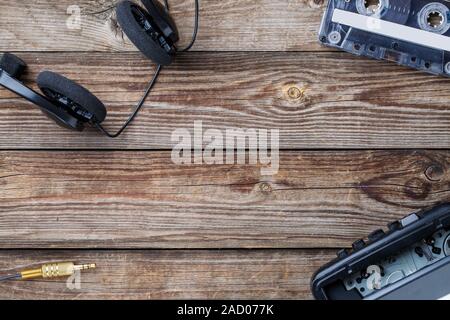 Cassette, lecteur de cassettes et d'écouteurs sur la table en bois. vue d'en haut. Banque D'Images