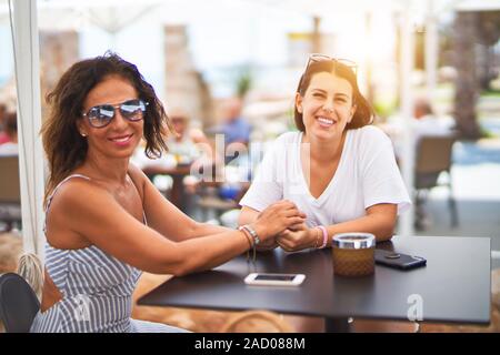 Belle Mère et fille assis à une terrasse de restaurant parlant et souriant Banque D'Images