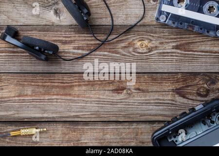 Cassette, lecteur de cassettes et d'écouteurs sur la table en bois. vue d'en haut. Banque D'Images