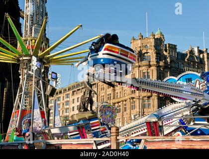 Yeti et Star Flyer manèges forains. Marché de Noël d'Édimbourg et juste. Magasin Jenners sur Princes Street en arrière-plan. L'Ecosse Banque D'Images