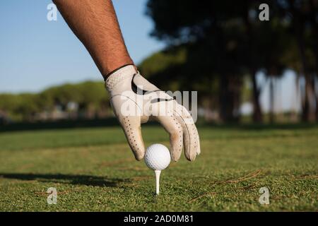 Close up de joueurs de golf ball on tee main mise Banque D'Images