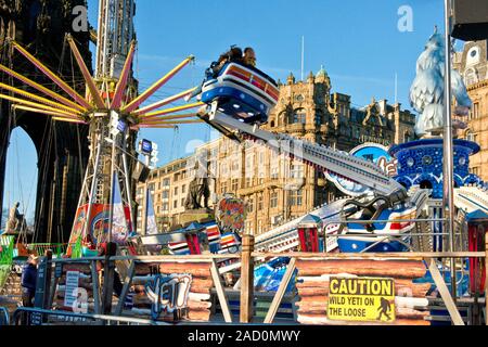 Yeti et Star Flyer manèges forains. Marché de Noël d'Édimbourg et juste. Magasin Jenners sur Princes Street en arrière-plan. L'Ecosse Banque D'Images