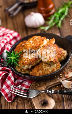 Escalopes de viande dans la poêle sur la table rustique en bois Banque D'Images