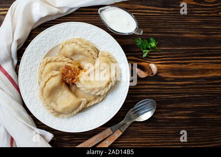 Vareniki Varenyky ou pyrohy, quenelles, pâtisserie traditionnelle orientale avec des pommes de terre farcies plat servi avec de la crème et oignons caramélisés Banque D'Images