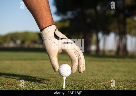 Close up de joueurs de golf ball on tee main mise Banque D'Images