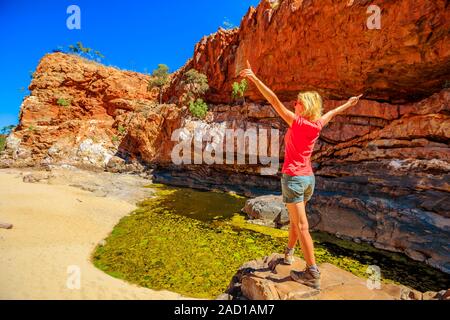 Carefree woman après Ormiston Pound à pied, un circuit qui suit la pente rocheuse dans des livres et en arrière le long de la gorge par point d'eau principal Banque D'Images