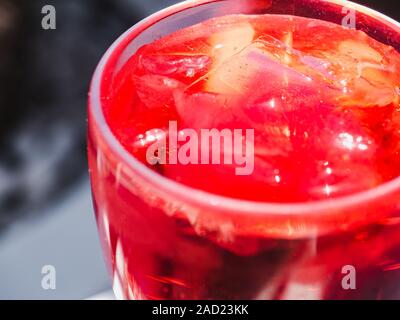 Avec un beau verre à cocktail rose et des cubes de glace, debout sur un tableau blanc contre l'ombre de feuilles de palmier. Vue de dessus, close-up. Le concept de Banque D'Images