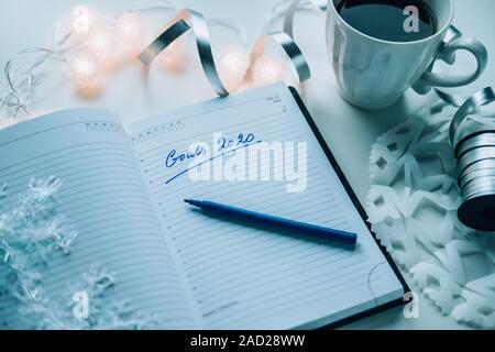 Objectifs de 2020 écrit sur un journal intime avec la lumière chaude, café ou thé et de décoration. Bonne Année et la motivation consept background Banque D'Images