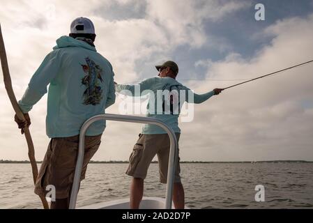 Ambergris Caye, Belize - 16 novembre, 2019. Guide de la pêche locale demande à un pêcheur de mouche sur casting technique utilisée dans l'eau salée qu'il pêche stan Banque D'Images