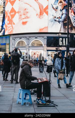 Londres, Royaume-Uni - 24 novembre 2019 : clavier et chant musicien ambulant jouant sur Piccadilly Circus, l'un des quartiers touristiques les plus populaires de Londres, Royaume-Uni, selecti Banque D'Images