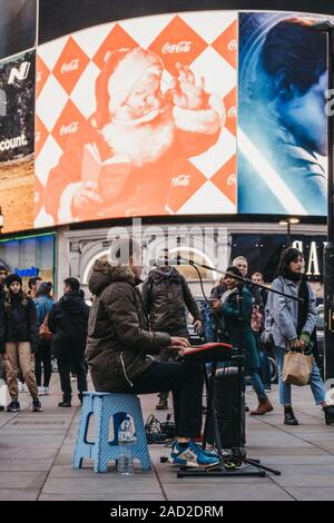 Londres, Royaume-Uni - 24 novembre 2019 : clavier et chant musicien ambulant jouant sur Piccadilly Circus, l'un des quartiers touristiques les plus populaires de Londres, Royaume-Uni, selecti Banque D'Images