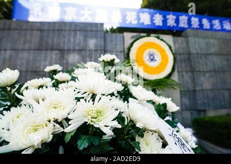 Nanjing, Chine. 06Th Dec, 2019. Photo prise le 3 décembre 2019, montre des fleurs devant l'memorial hall mur où les noms des victimes sont gravés au cours d'une activité de commémoration à Nanjing, capitale de la province de Jiangsu, Chine orientale. Dès le Mardi, les membres des familles des victimes du massacre a commencé une série d'activités de commémoration comme jeter des fleurs et de l'encens devant le mur où les noms des victimes sont gravés. Le massacre de Nanjing a eu lieu lorsque les troupes japonaises ont pris la ville, capitale de la Chine, le 13 décembre, 1937. Source : Xinhua/Alamy Live News Banque D'Images