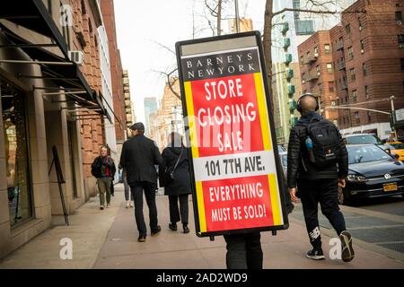 Un travailleur à l'extérieur du magasin Barneys sur la 7ème Avenue à New York annonce que le magasin est la liquidation, vu le Samedi, Novembre 23, 2019. L'emblématique des avant-postes de la mode ont été vendues à B. Riley, la liquidation financière, tandis que les spécialistes de la propriété intellectuelle marques authentiques de groupe. (© Richard B. Levine) Banque D'Images