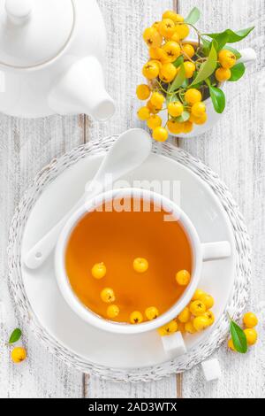 Les frais d'aubépine à base de thé avec les baies fraîches dans une tasse blanche sur fond de bois, la médecine alternative Banque D'Images