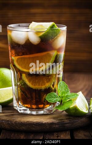 Cocktail Cuba Libre avec cola, citron vert et de glace en verre, longdrink froid Banque D'Images