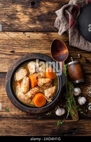 À l'étuvée avec viande en sauce carottes et épices en fonte pot sur fond rustique en bois foncé Banque D'Images