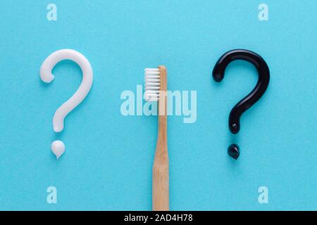 Question du blanc et noir, des dents dentifrice, brosse à dents en bois concept Soins sur fond bleu Banque D'Images