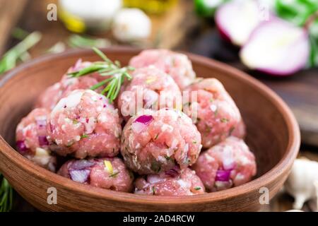 Boulettes de viande crue close-up sur fond de bois Banque D'Images