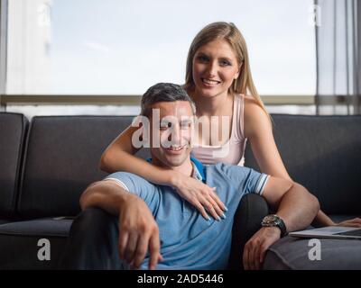 Beau couple à l'aide d'un laptop on couch Banque D'Images