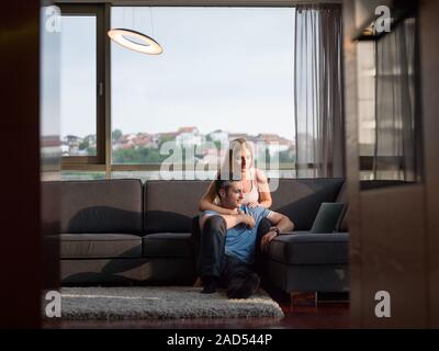 Beau couple à l'aide d'un laptop on couch Banque D'Images