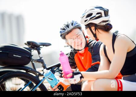 Deux cyclistes assis sur un banc Banque D'Images