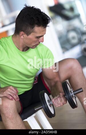 Handsome man working out with dumbbells Banque D'Images