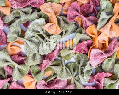 Pile de Tri séchées italiennes pâtes farfalle Couleur arrière-plan, différentes couleurs de sangle Banque D'Images