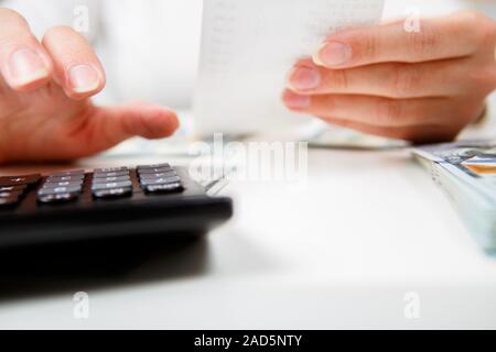 L'épargne, finances publiques, économie et accueil concept - close up des mains avec de l'argent comptant calculatrice et prendre des notes à la maison Banque D'Images