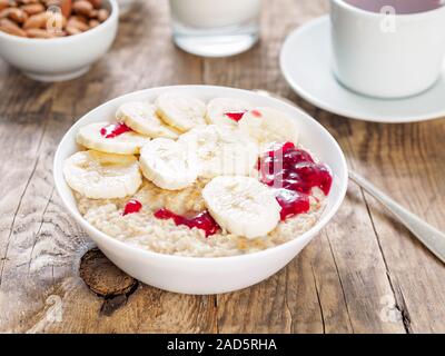 Un petit-déjeuner végétarien est servi le matin, y compris d'avoine, des tranches de banane et confiture de framboises. Un bon nombre de glucides lents Banque D'Images