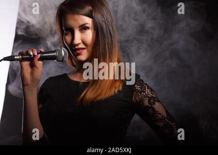 Jeune femme chante en studio Banque D'Images