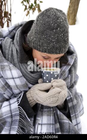 Pique-nique d'hiver chaud avec soupe de pommes de terre - une femme (enveloppé dans une couverture à carreaux gris) dans une tasse de soupe boissons UK  + droits irlandais uniquement. Banque D'Images