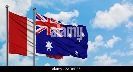 Le Pérou et l'Australie drapeaux dans le vent contre ciel bleu nuageux blanc ensemble. Concept de diplomatie, de relations internationales. Banque D'Images