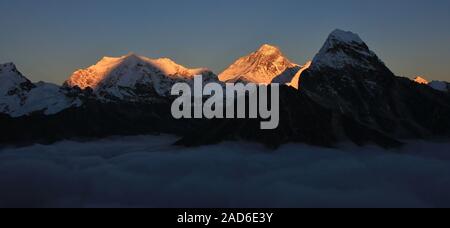 Lobuche East, le mont Everest et le Cholatse vu de la vallée de Gokyo. Coucher du soleil sur un fogy journée d'automne. Banque D'Images