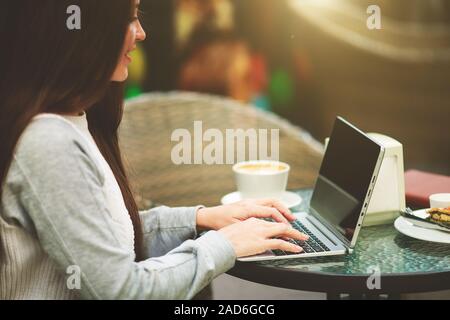 Portrait d'un female office worker relaxing in cafe après une longue journée de travail. Close-up de main de femme chargée de taper au clavier tout en assise à son lieu de travail au bureau Banque D'Images